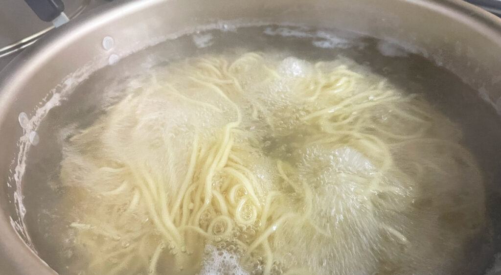 鍋で麺を茹でる